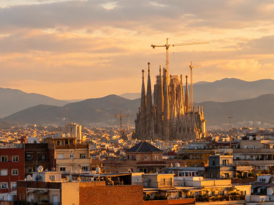 Sagrada Família rising above Barcelona rooftops at golden hour